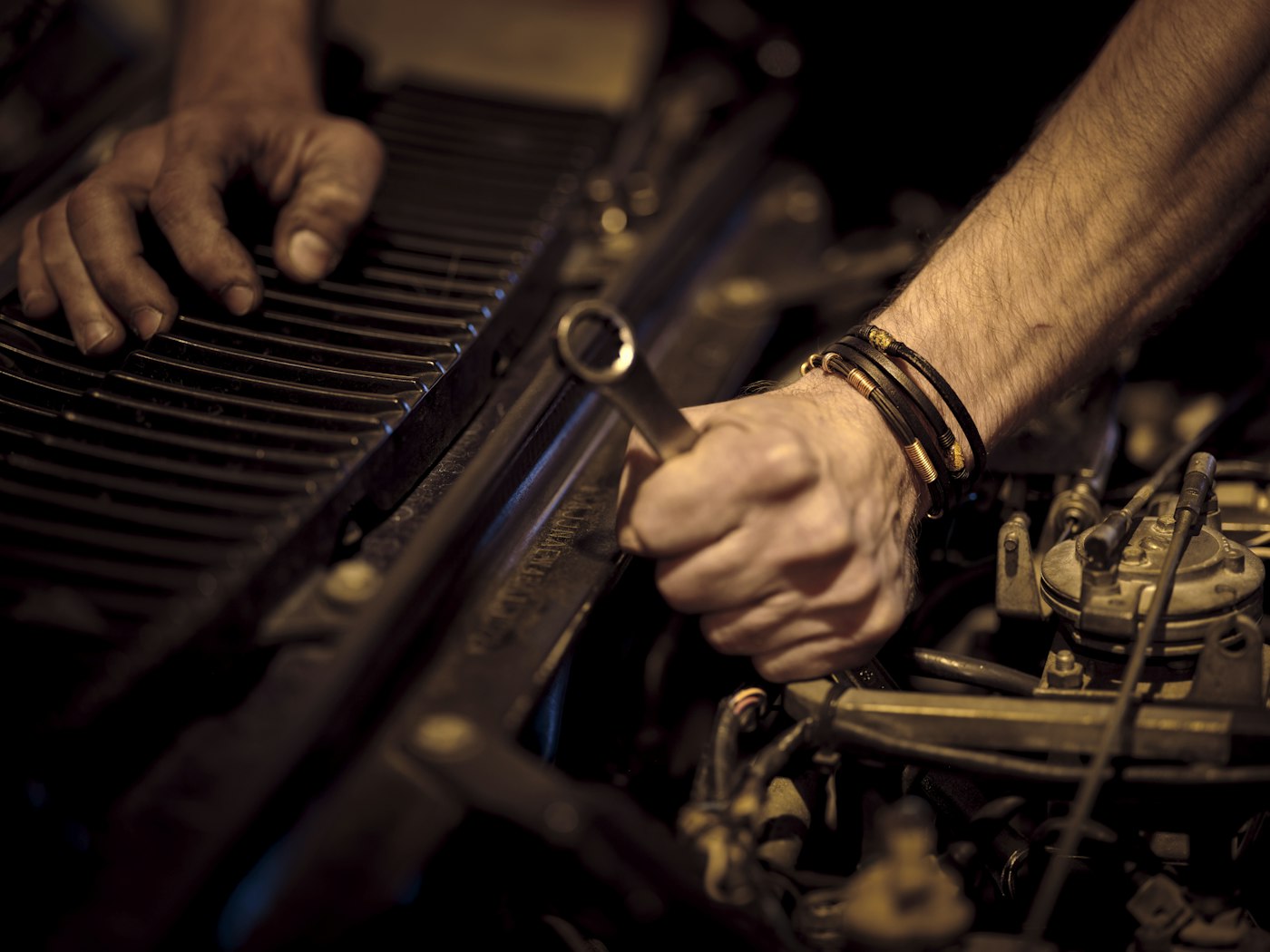 Hands using a wrench on an engine
